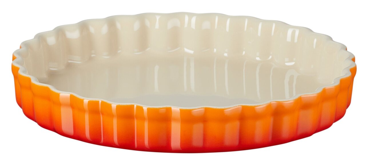 Runde Tarte-Form in Ofenrot, seitliche Perspektive, mit gewelltem Rand und cremefarbener Innenseite.