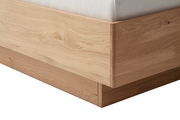 Nahaufnahme eines Bettrahmens aus hellem Holz mit klaren Linien und natürlicher Maserung, seitliche Perspektive.