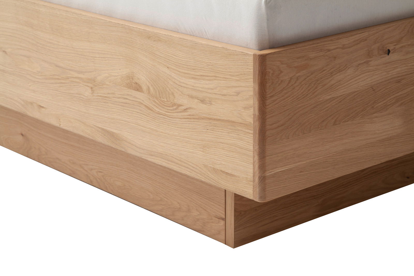 Nahaufnahme eines Bettrahmens aus hellem Holz mit klaren Linien und natürlicher Maserung, seitliche Perspektive.