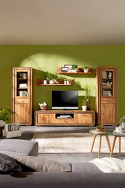 Wohnzimmermöbel-Set aus Holz mit TV-Tisch, Vitrinen und Wandregalen, frontal fotografiert vor einer grünen Wand.