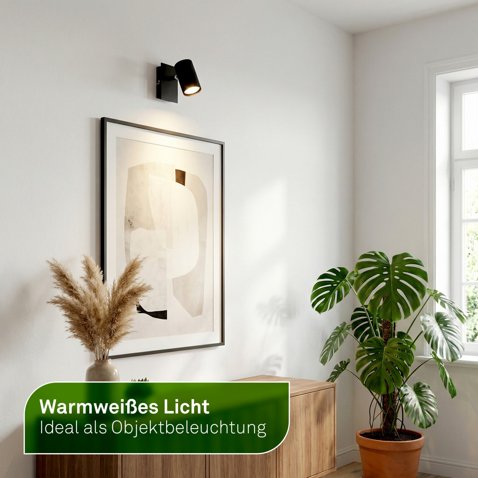 Schwarzer, schwenkbarer Wandspot mit warmweißem Licht zur Objektbeleuchtung, aus seitlicher Perspektive in einem modernen Wohnraum gezeigt.