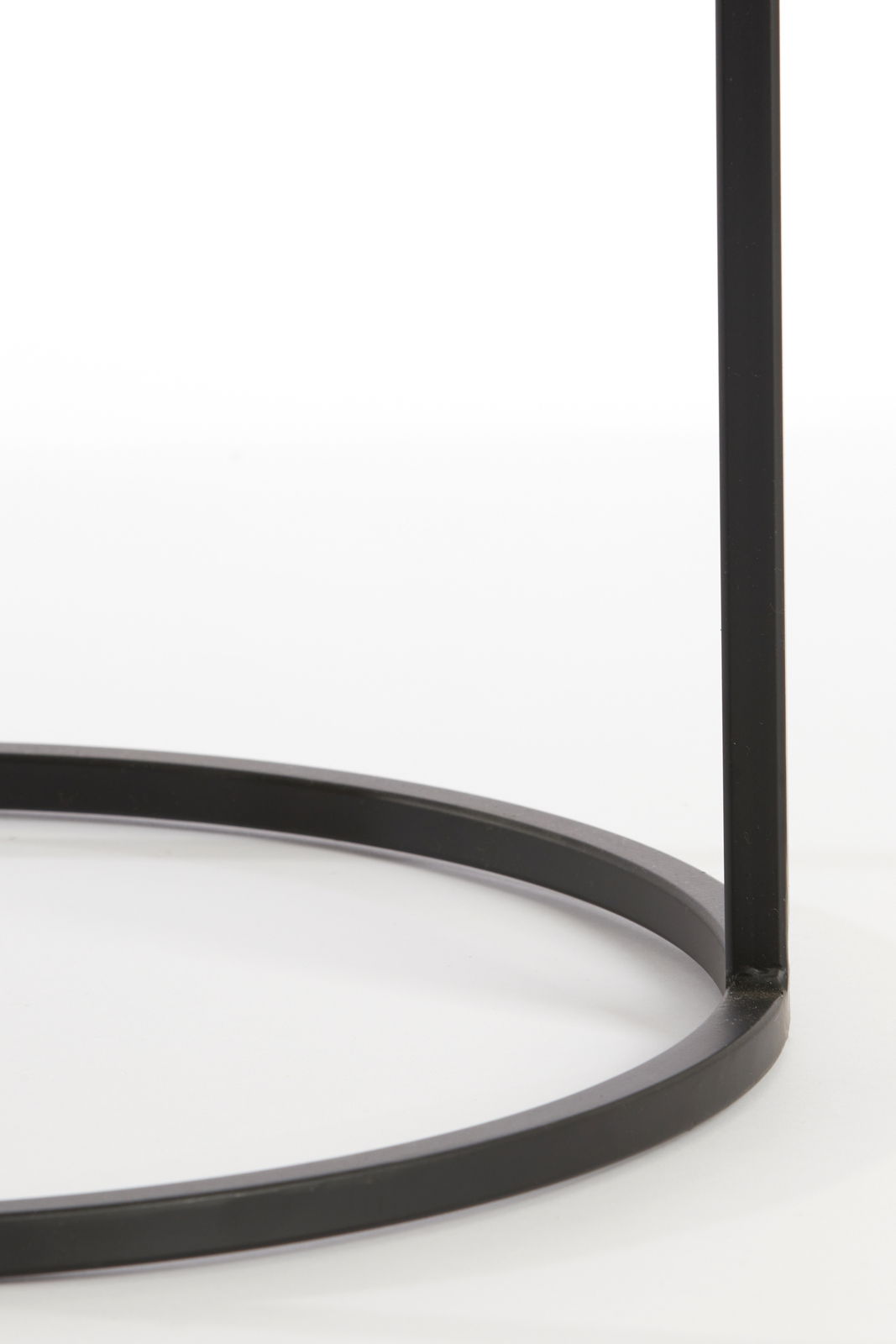 Nahaufnahme eines schwarzen Metallgestells eines Beistelltisches, von der Seite betrachtet.