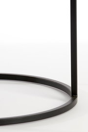 Nahaufnahme eines schwarzen Metallgestells eines Beistelltisches, von der Seite betrachtet.