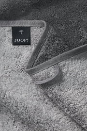 Graues Handtuch von JOOP! in Nahaufnahme, zeigt die weiche Textur und das Etikett, Perspektive von oben.