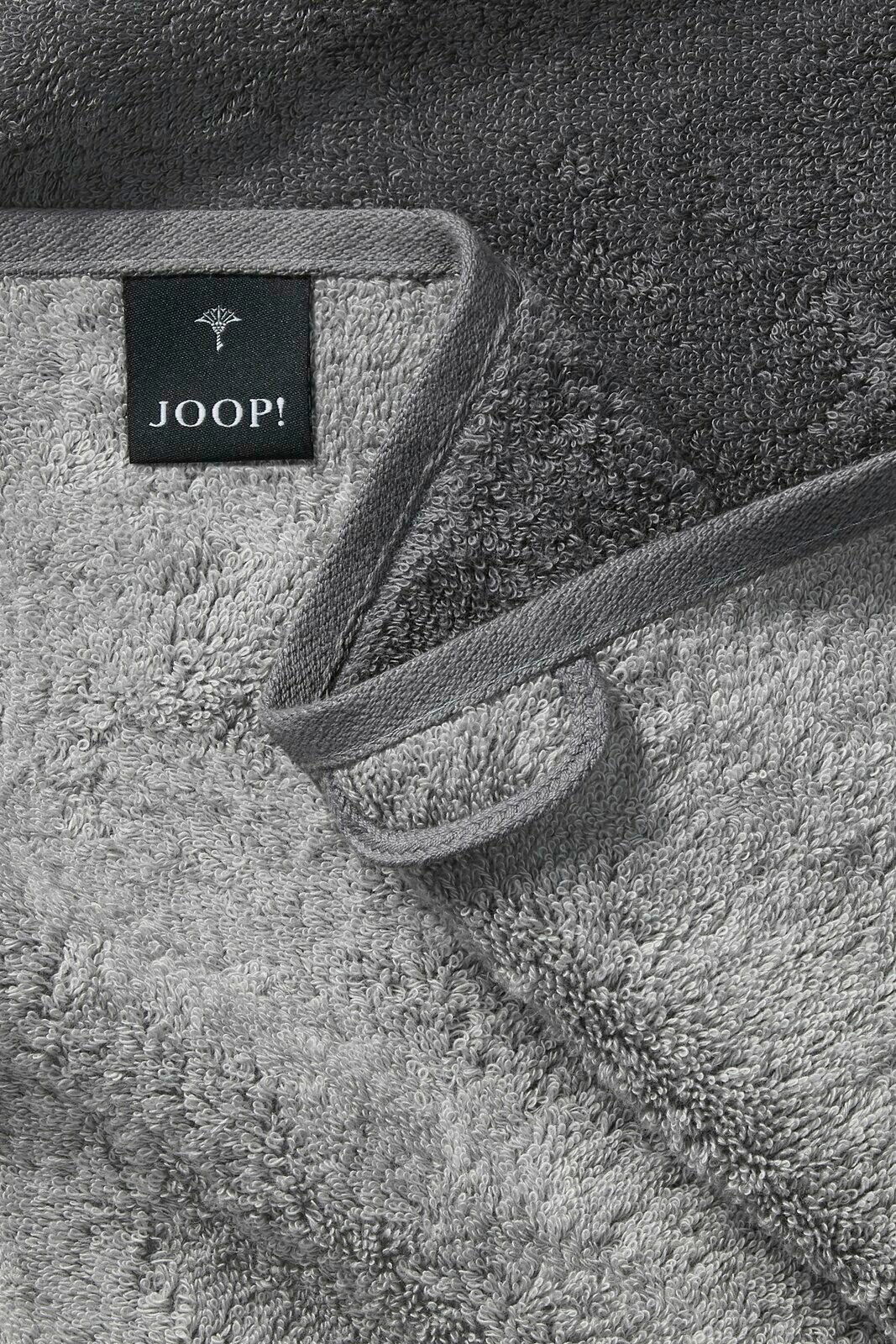 Graues Handtuch von JOOP! in Nahaufnahme, zeigt die weiche Textur und das Etikett, Perspektive von oben.