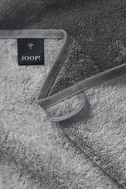 Grijze handdoek van JOOP! in close-up, met de zachte textuur en het label, gezien van bovenaf.