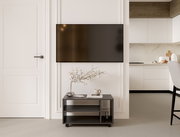 Moderner TV-Rollwagen in einem stilvollen Wohnzimmer, frontal betrachtet, mit Dekorationen wie einer Vase und einer Tasse darauf.