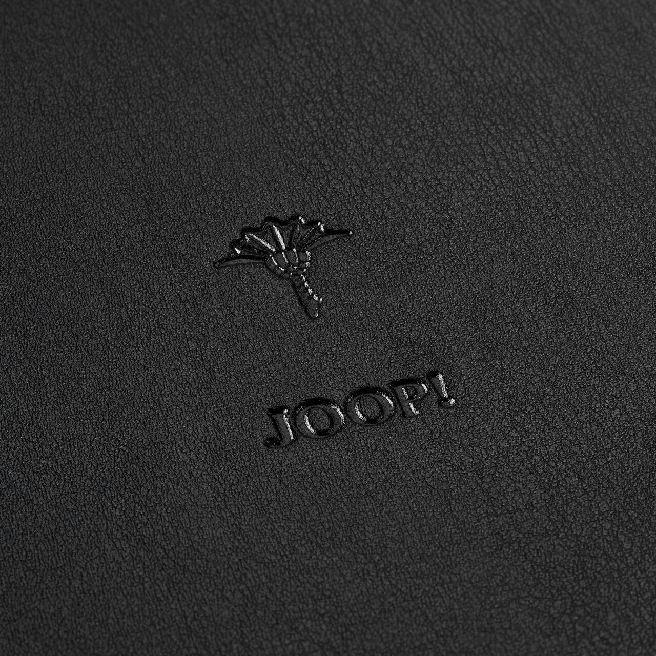 Nahaufnahme eines schwarzen runden Tabletts mit geprägtem Logo und Text 'JOOP!'