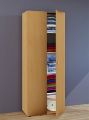 Hoher, schmaler Kleiderschrank in heller Holzoptik mit zwei Türen, eine Tür geöffnet und gefüllte Regalböden sichtbar; Ansicht schräg von vorn vor grauer Wand auf Holzboden.