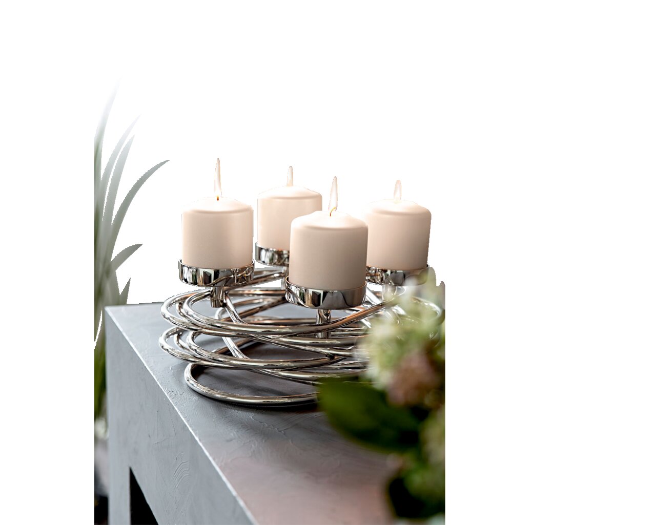Moderner silberner Kerzenhalter mit vier brennenden weißen Kerzen, auf einem Tisch von schräg oben fotografiert.