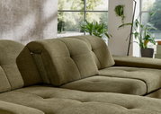 Groene longchair-set in een moderne woonkamer met grote ramen en planten, zijaanzicht