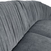 Nahaufnahme eines grauen, runden Megasofas mit gerafftem Stoffbezug, seitliche Perspektive