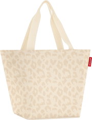Beige Stoff-Shopper mit dezentem Leo-Muster und langen Tragehenkeln, Frontansicht leicht schräg von vorn, mit rotem seitlichem reisenthel-Label vor weißem Hintergrund.