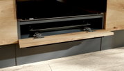 Open neerklapbare keukenfront/klep in houtlook met metalen scharnieren in een moderne grijze keuken, frontaal perspectief