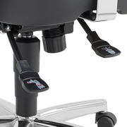 Nahaufnahme der Mechanik eines Drehsessels mit Hebeln und Rollen, seitliche Perspektive