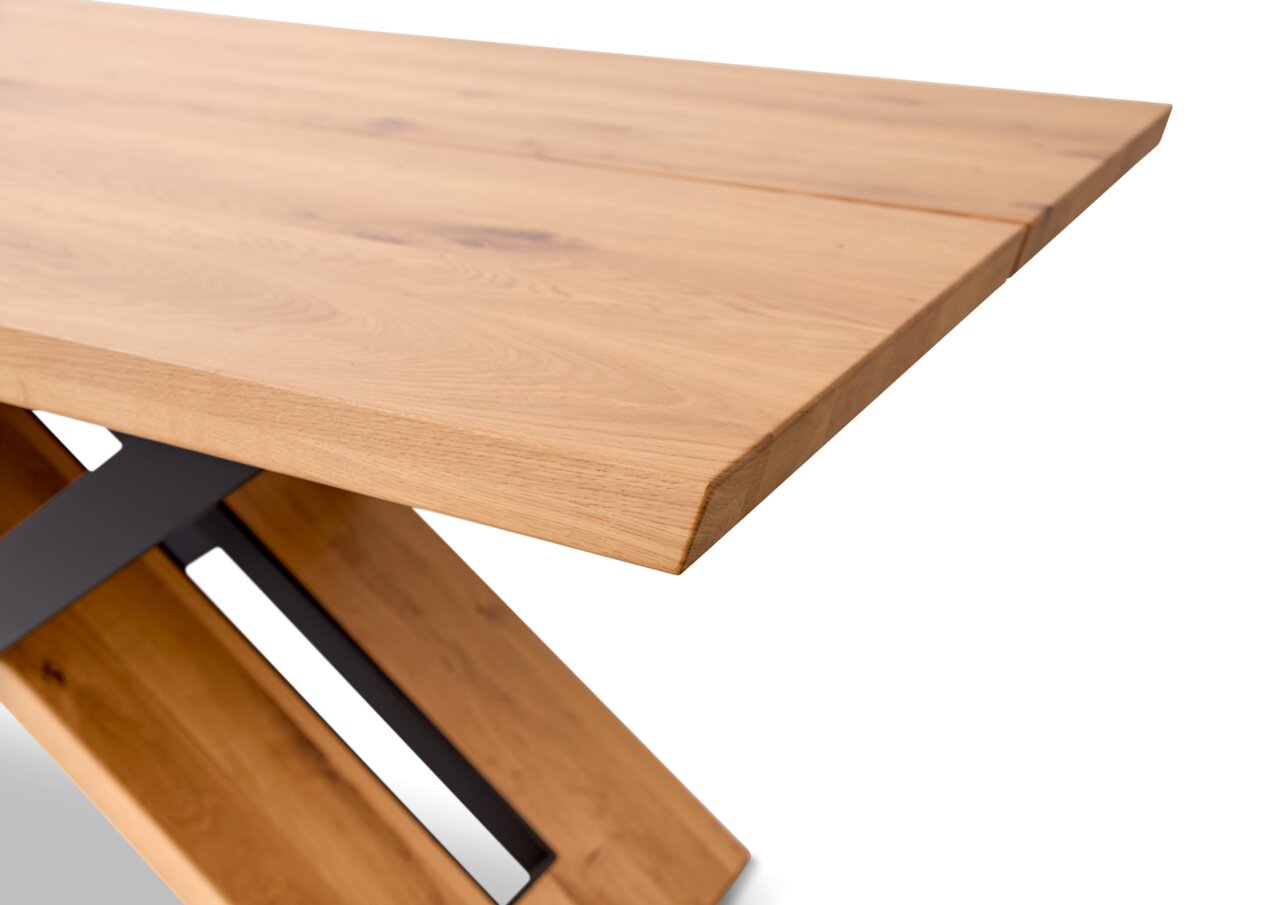 Nahaufnahme eines modernen Esstisches aus Holz mit schräger Perspektive auf die Tischplatte und das Gestell.