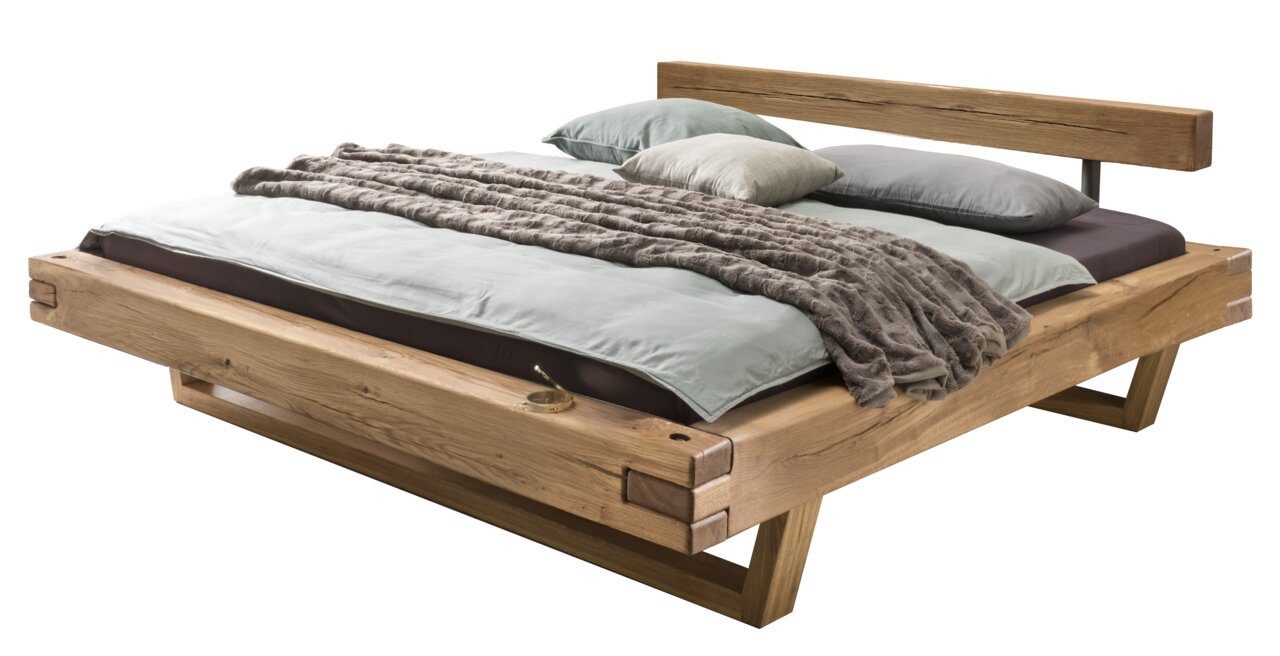 Holzbalkenbett mit Kopfteil, seitliche Perspektive, mit Kissen und Decke dekoriert.