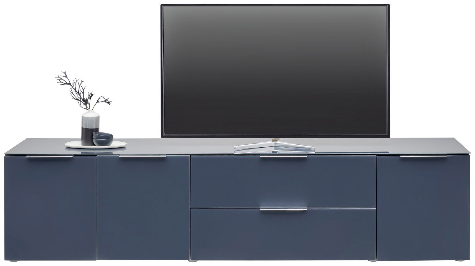 Frontale Ansicht eines modernen XL-TV-Lowboards in dunklem Blau mit mehreren Schubladen und Türen, dekoriert mit einer Vase und einer Schale.