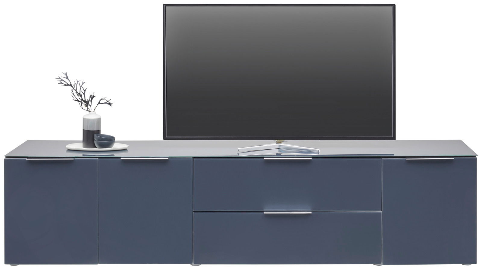 Frontale Ansicht eines modernen XL-TV-Lowboards in dunklem Blau mit mehreren Schubladen und Türen, dekoriert mit einer Vase und einer Schale.