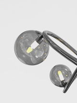 Moderne Pendelleuchte Nancy mit zwei rauchgrauen Glaskugeln und geschwungenem Metallrahmen, seitliche Perspektive