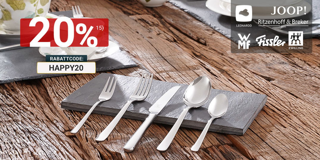 Gedeckter Holztisch mit weißem Geschirr mit Blattmotiv und glänzendem Besteck auf Schieferplatten im natürlichen Ambiente