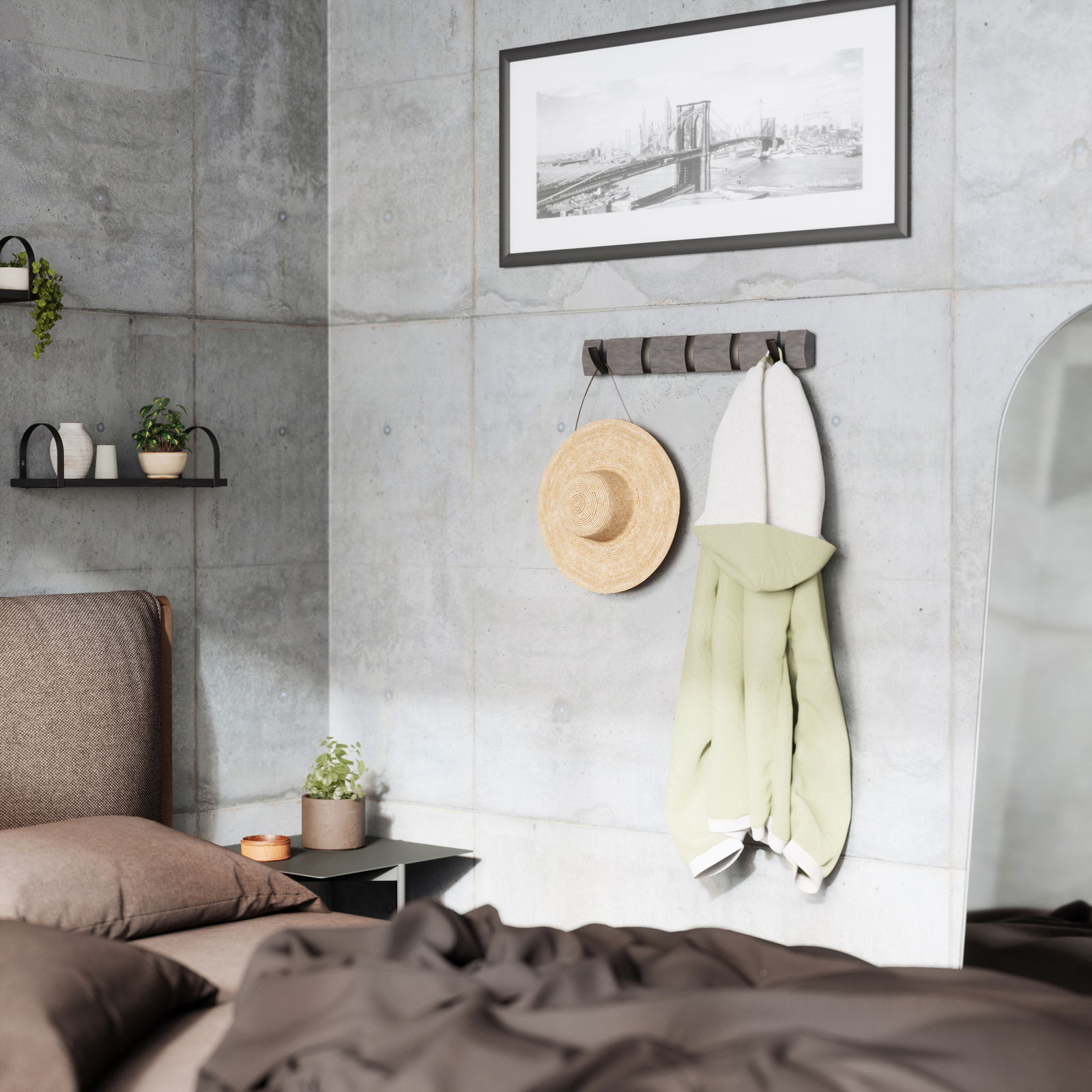 Moderne Wandgarderobe mit Haken, an der ein Strohhut und ein grüner Mantel hängen, in einem stilvoll eingerichteten Schlafzimmer mit Betonwänden. Perspektive von der Seite.