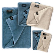Badstofset van 5 stuks in blauw en beige, gefotografeerd van bovenaf, bestaande uit handdoeken in verschillende maten.