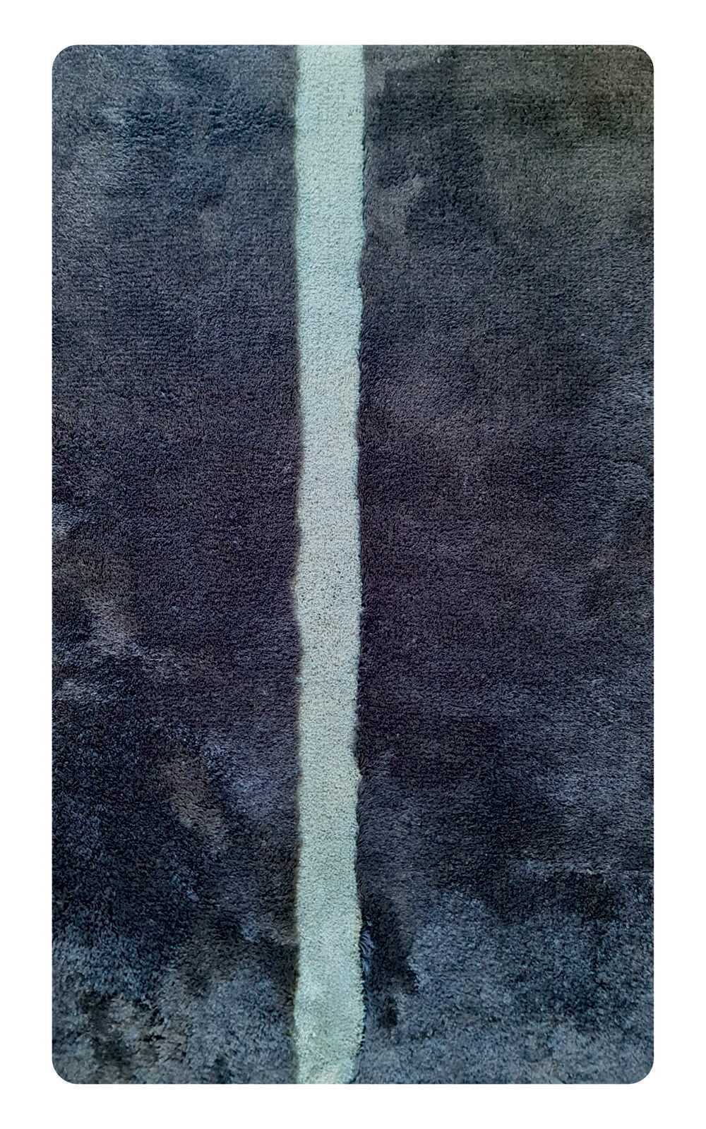 Badteppich in Dunkelgrau mit einem hellen Streifen in der Mitte, von oben betrachtet.