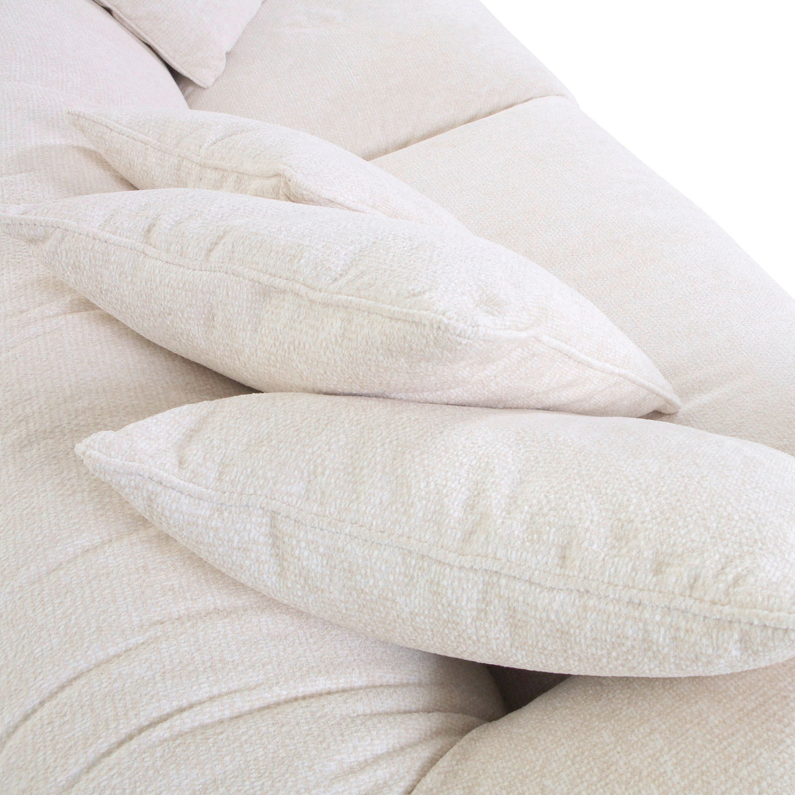 Nahaufnahme von beigen Kissen auf einem Big-Sofa, seitliche Perspektive.