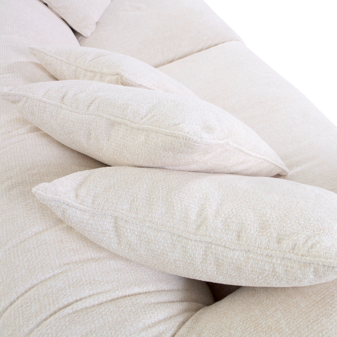 Nahaufnahme von beigen Kissen auf einem Big-Sofa, seitliche Perspektive.