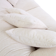 Nahaufnahme von beigen Kissen auf einem Big-Sofa, seitliche Perspektive.