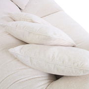 Nahaufnahme von beigen Kissen auf einem Big-Sofa, seitliche Perspektive.