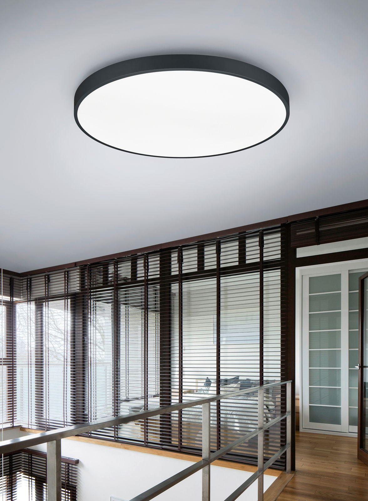 Runde LED-Deckenleuchte WACO, 102W, 2300K, 3000K, von unten betrachtet in einem modernen Raum mit großen Fenstern und Jalousien.