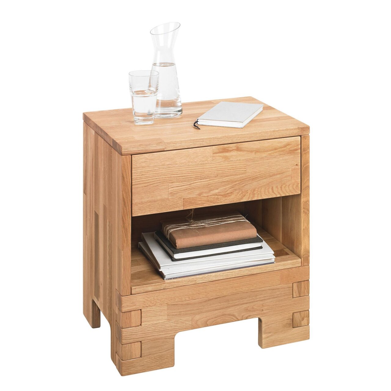 Nachtkommode aus Holz mit Schublade und offenem Fach, frontal fotografiert, mit Glas, Karaffe und Notizbuch darauf.