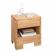 Nachtkommode aus Holz mit Schublade und offenem Fach, frontal fotografiert, mit Glas, Karaffe und Notizbuch darauf.