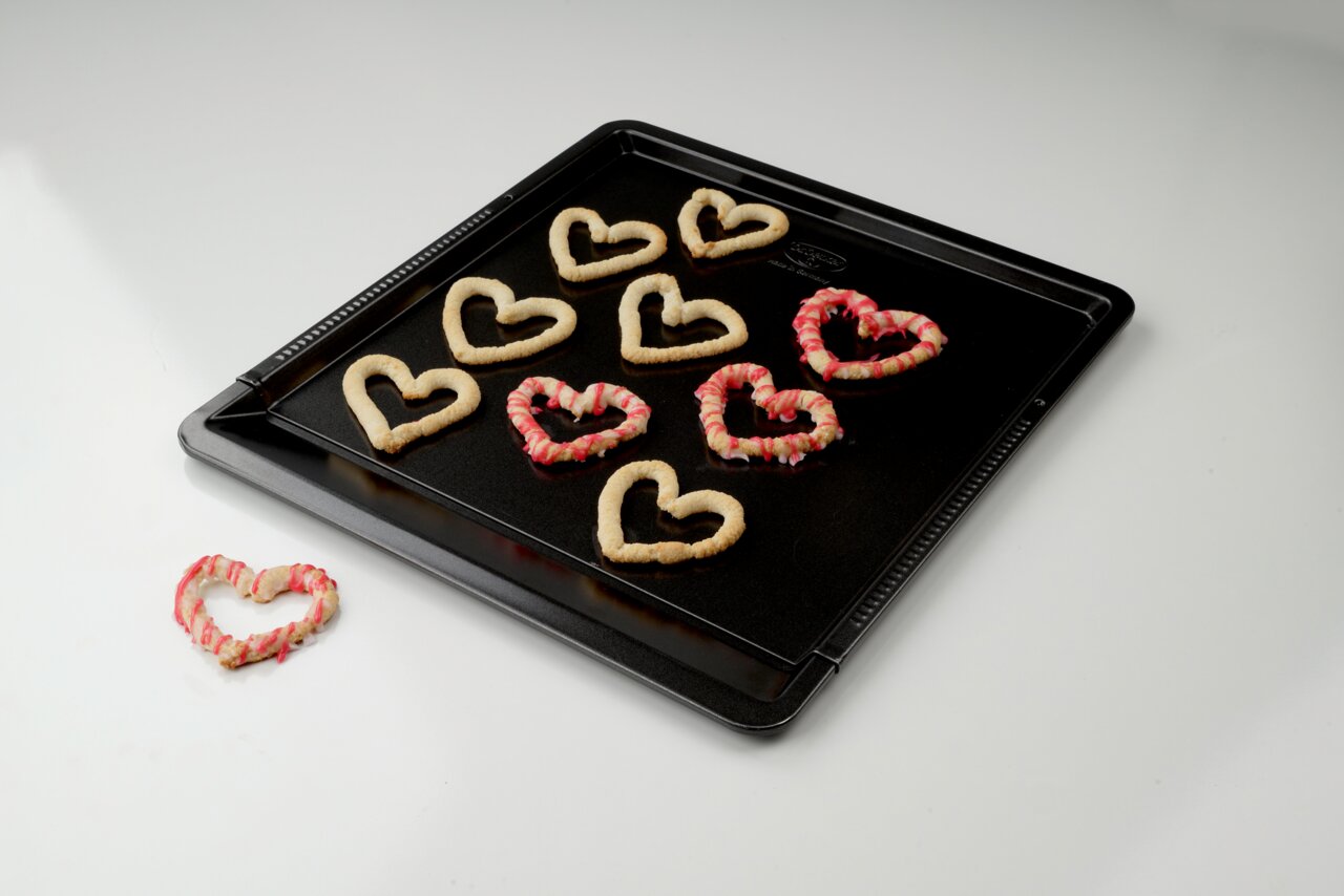 Een bakplaat met hartvormige koekjes, van bovenaf gefotografeerd