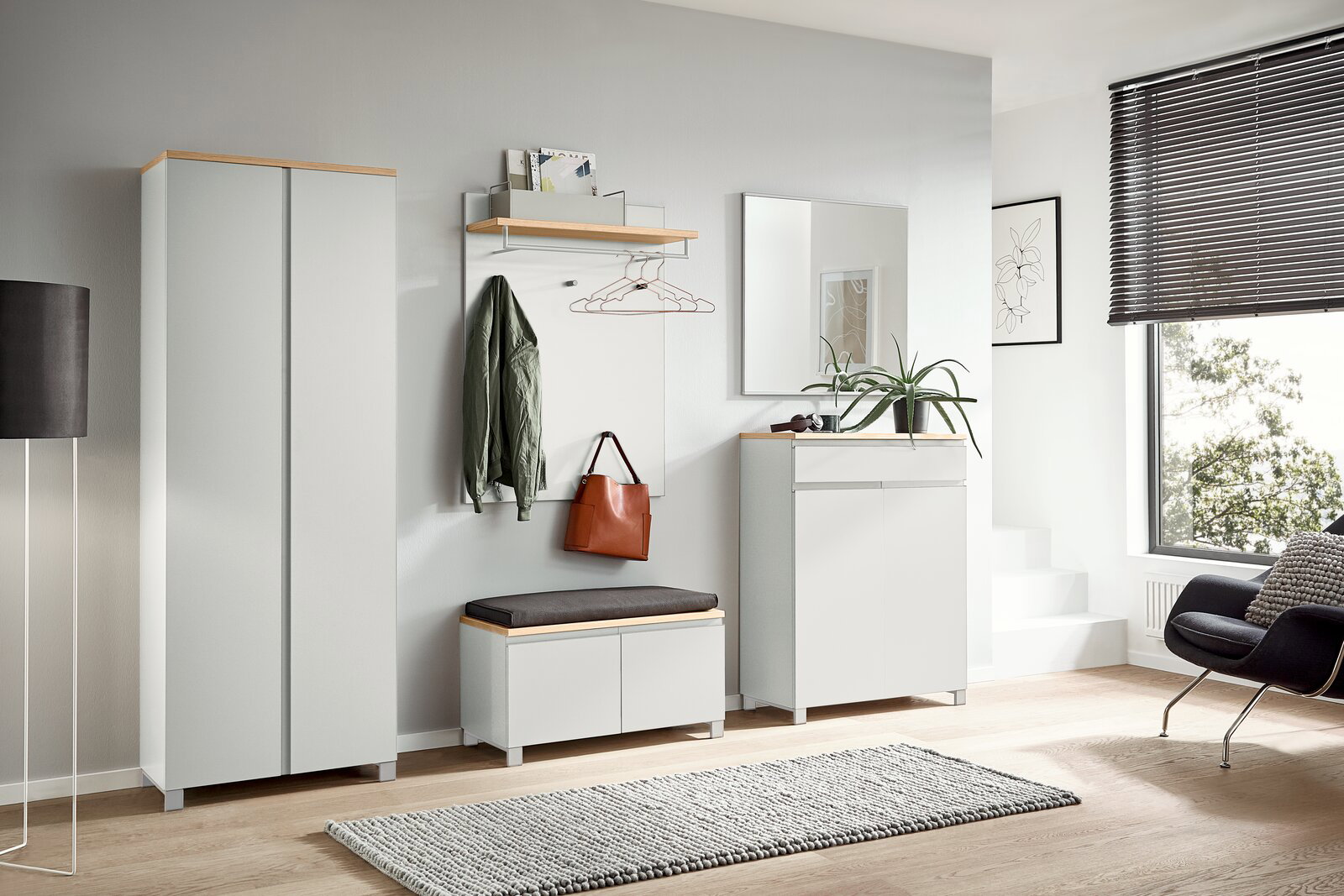 Moderne Garderobeneinrichtung mit Schuhschrank, Sitzbank und Spiegel in heller, minimalistischer Raumgestaltung. Frontalansicht.