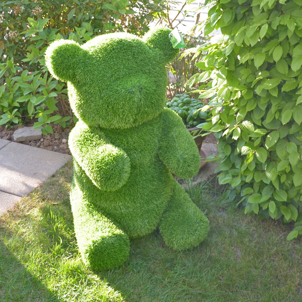 Grüner Bär aus Kunstrasen, frontal im Garten platziert
