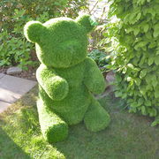 Grüner Bär aus Kunstrasen, frontal im Garten platziert