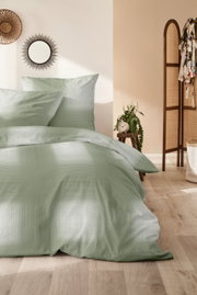 Groen beddengoed van 135 x 200 cm in een stijlvol ingerichte slaapkamer, zijaanzicht