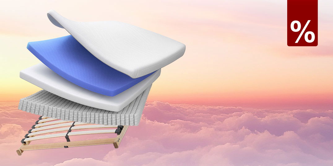 Explosionsdarstellung einer Matratze mit Schaum- und Federkernschichten sowie Lattenrost vor Himmelshintergrund