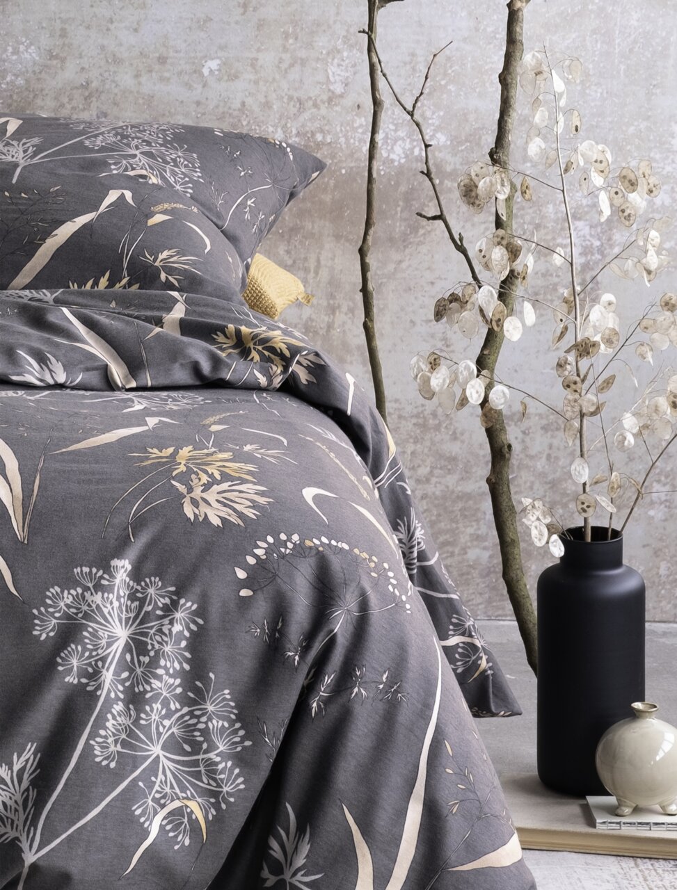 Bettwäsche-Set in 155x220cm mit floralem Muster in Grau- und Beigetönen, dekoriert mit Trockenblumen und Vasen, seitliche Perspektive.
