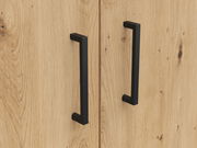 Nahaufnahme von zwei schwarzen Griffen auf einer Holzoberfläche, perspektivisch von vorne betrachtet.