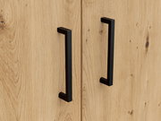 Nahaufnahme von zwei schwarzen Griffen auf einer Holzoberfläche, perspektivisch von vorne betrachtet.