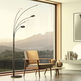 Moderne Stehleuchte Dent mit mehreren gebogenen Armen und runden Leuchtelementen, in einem stilvollen Wohnzimmer mit großem Fenster und Bergblick, aus seitlicher Perspektive.