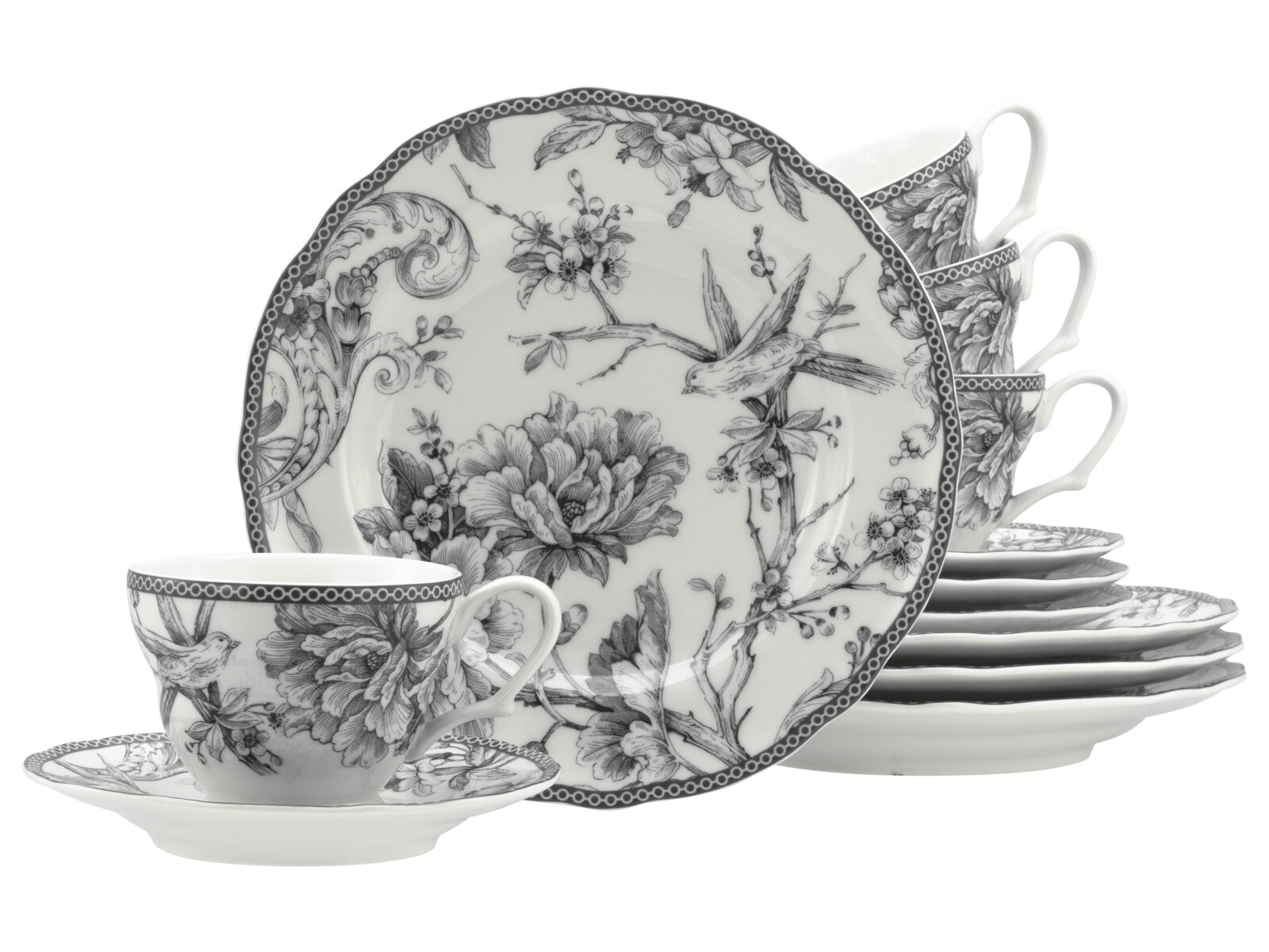 Schwarz-weißes Porzellan-Kaffeegeschirr mit floralen und Vogel-Motiven: große Speiseteller im Hintergrund, gestapelte Untertassen und mehrere Tassen Ansicht leicht schräg von vorne.
