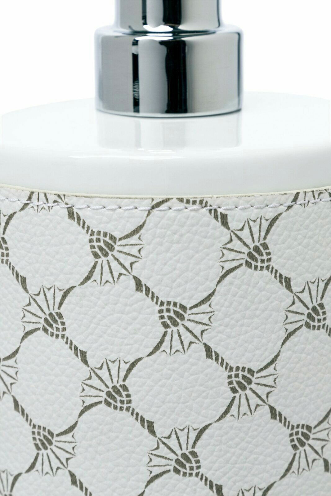 Nahaufnahme eines weißen Porzellan-Seifenspenders mit dekorativem Muster und glänzendem Chrom-Pumpkopf, seitliche Perspektive.