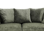 Nahaufnahme eines grünen Megasofas mit weichen, strukturierten Kissen.