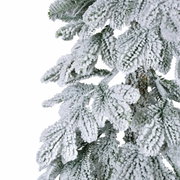 Close-up van met sneeuw bedekte takken van een kunstmatige spar, gezien vanaf de zijkant.