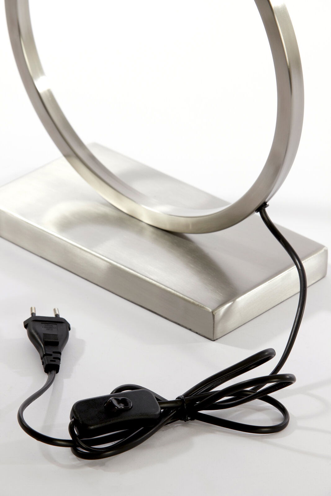 Nahaufnahme eines modernen Lampenfußes aus Metall mit rundem Design, Kabel und Schalter sichtbar, seitliche Perspektive